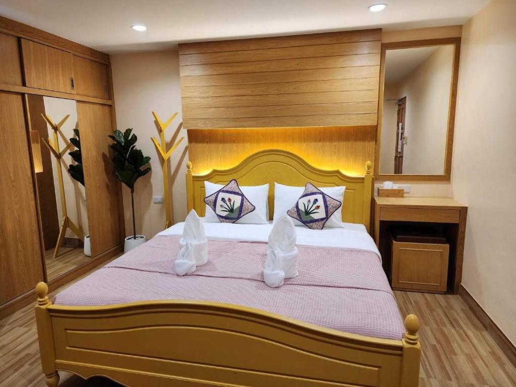 芭东海滩Alaita Hostel Patong的一间卧室配有一张大床和木制床头板