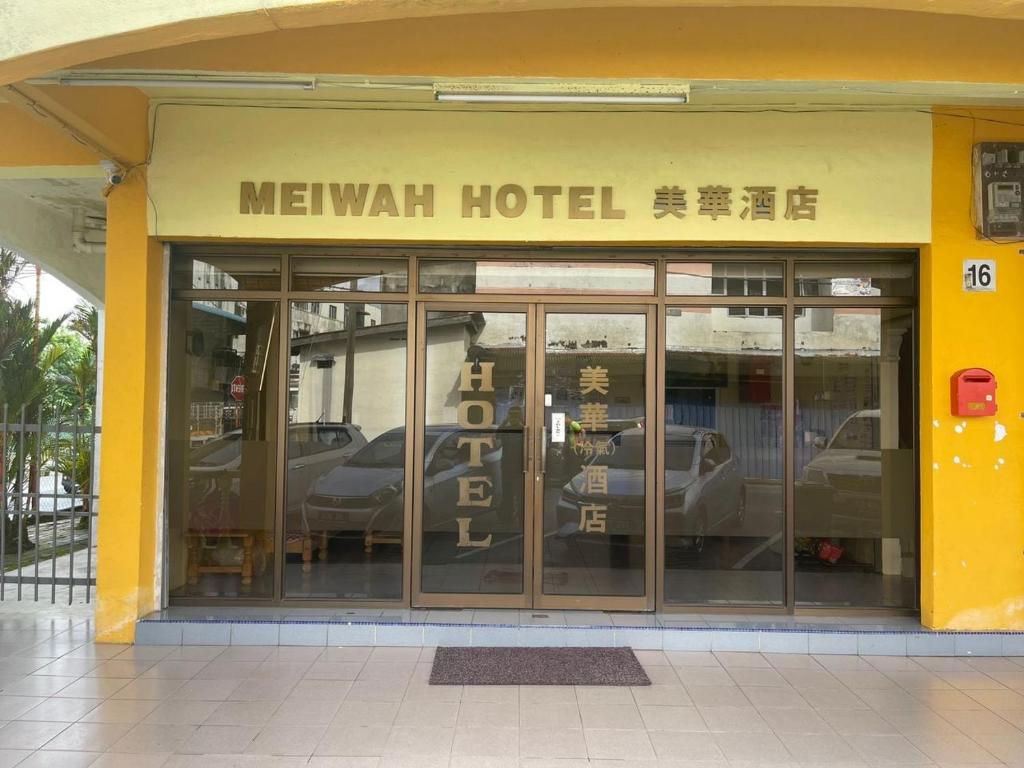 Kampong SelanchorOYO 90914 Hotel Mei Wah的一辆装有车的墨西哥酒店,窗户上反射着汽车