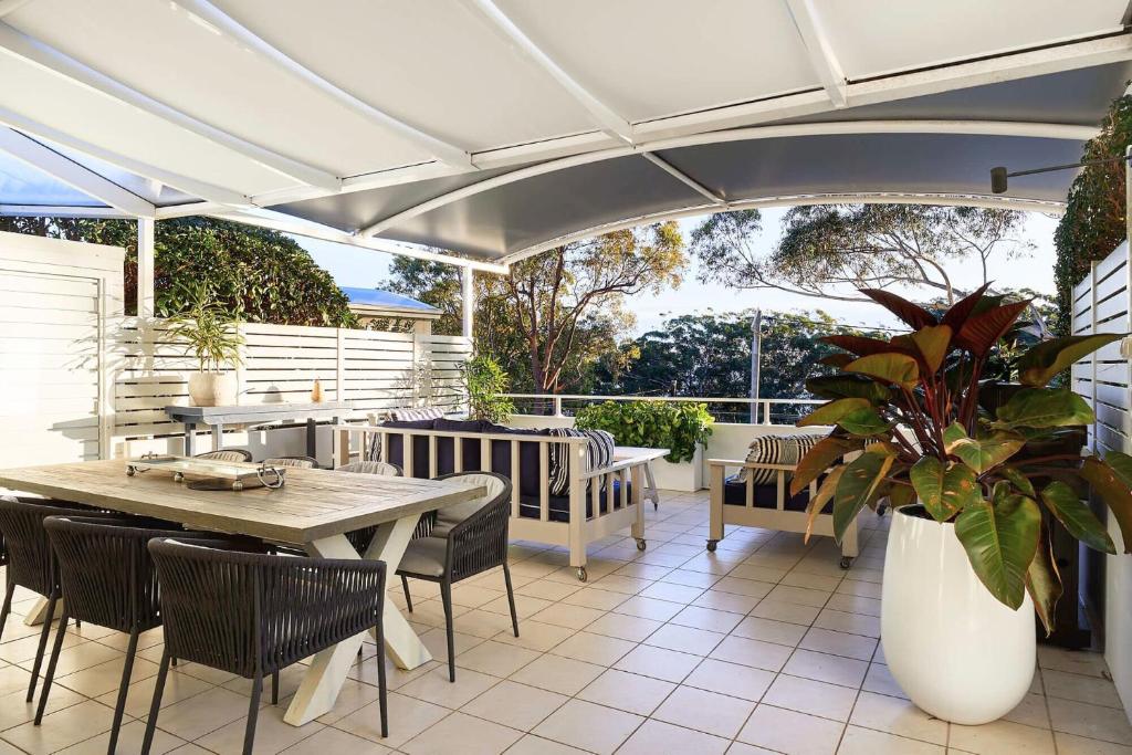 尼尔森湾Arabella的庭院配有桌椅和遮阳伞。