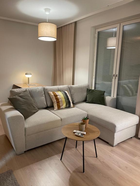 万塔Helsinki Airport Apartment的客厅配有沙发和桌子