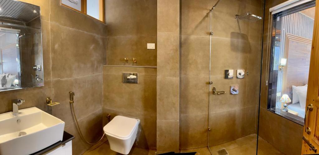 穆索里New Kempty Fall Hotel的带淋浴、卫生间和盥洗盆的浴室