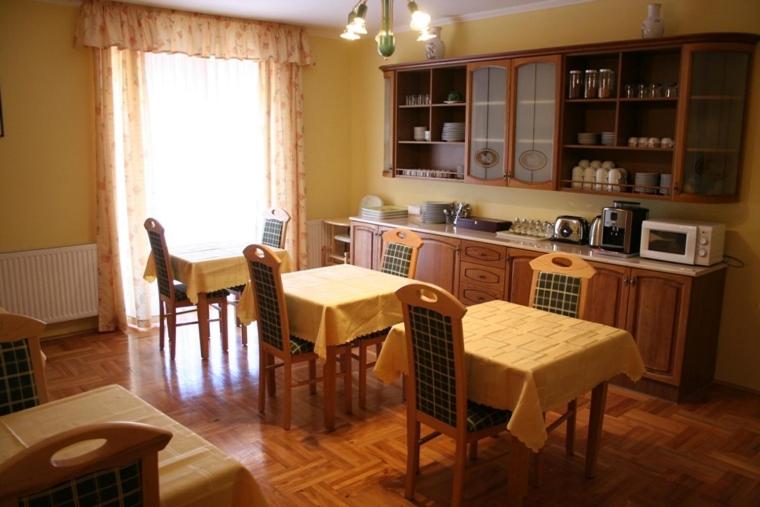 德布勒森欧罗盘兹奥酒店的一间带2张桌子和椅子的厨房以及一间配有微波炉的厨房