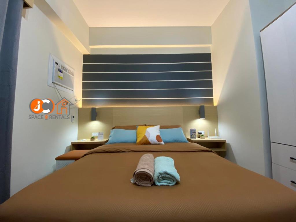 PusokJC SpaceRentals 127B Amani Grand Resort Residences, balcony pool view, Ground floor, 5 mins frm airport, free wifi, Netflix的一间卧室配有一张大床和两条毛巾