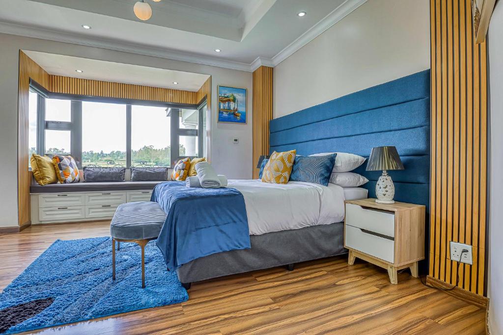 约翰内斯堡Villa Tasha Luxury Suites, Lanseria的一间卧室配有一张大床和蓝色床头板