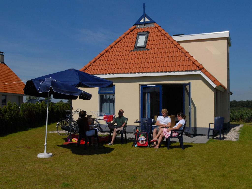 SuameerDetached villa with dishwasher Leeuwarden at 21km的一群人坐在房子前面的院子里