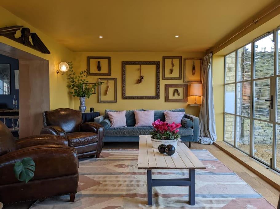 切尔滕纳姆Stylish 3 bed Cotswold cottage with stunning views的客厅配有沙发和桌子