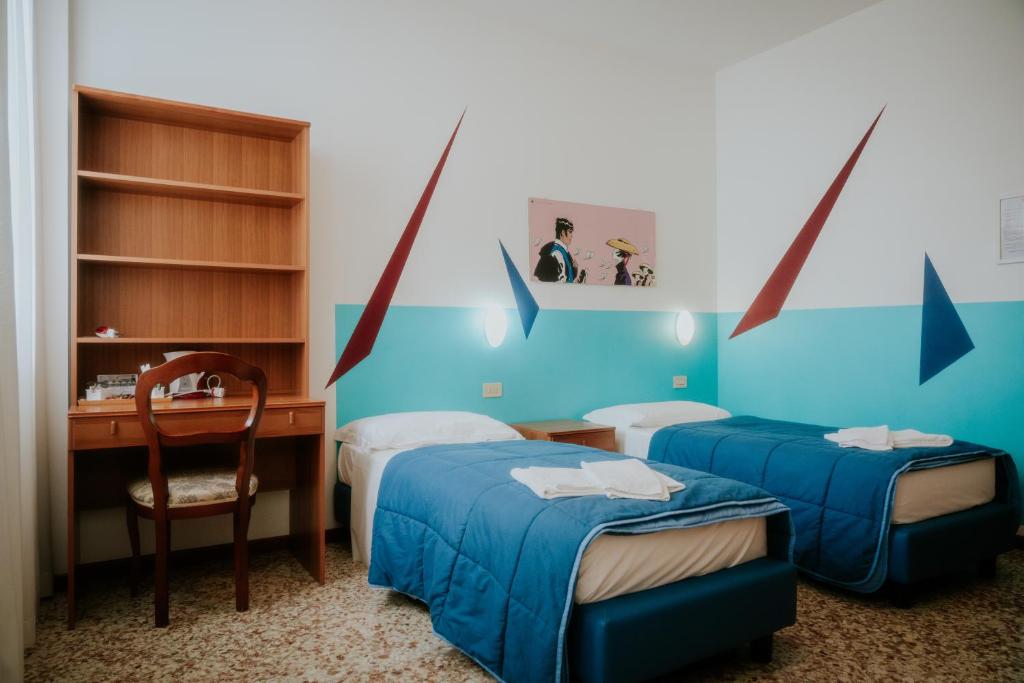 威尼斯卡萨艾卡达米亚旅舍的客房设有两张床、一张桌子和一把椅子。