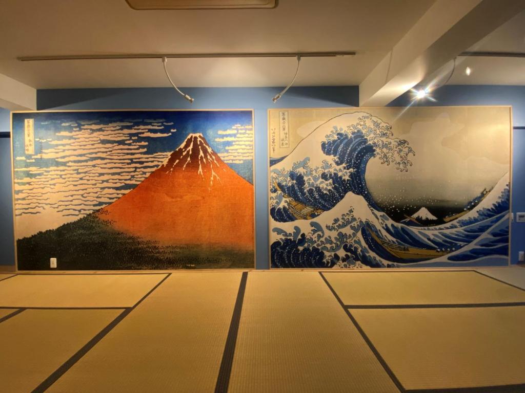 大阪Osaka Ukiyoe Ryokan的墙上有两幅波浪画的房间