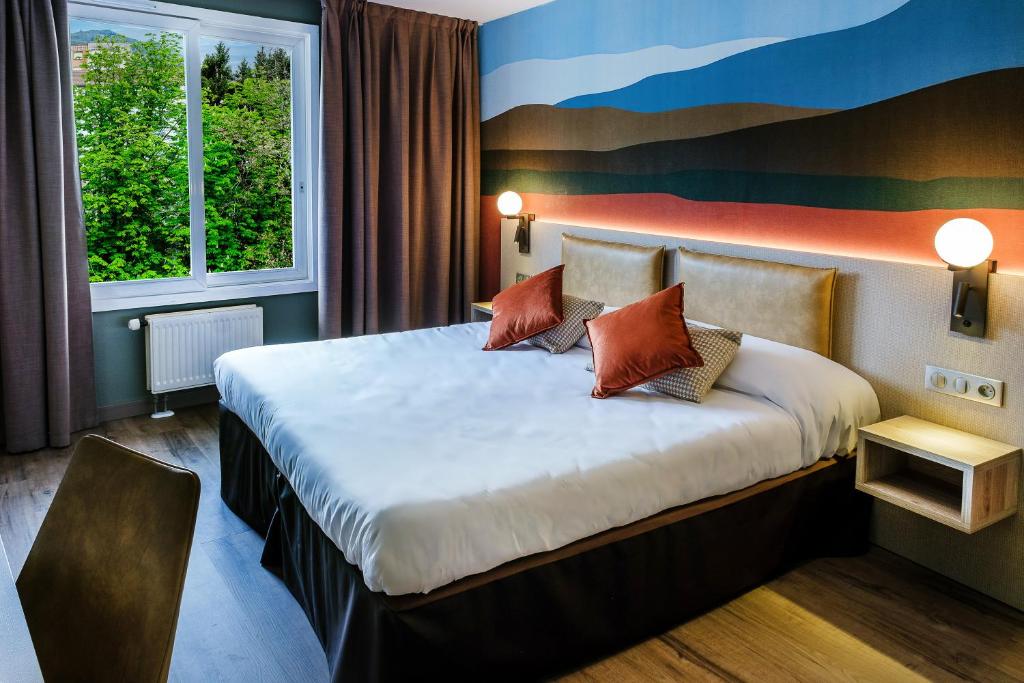 卢尔德清静酒店的酒店客房配有一张带枕头的大床