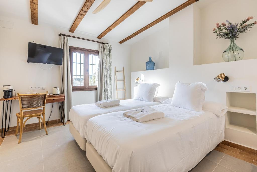 塞维利亚Hotel Rural Ganadería Virgen María的卧室配有一张白色大床和一张书桌