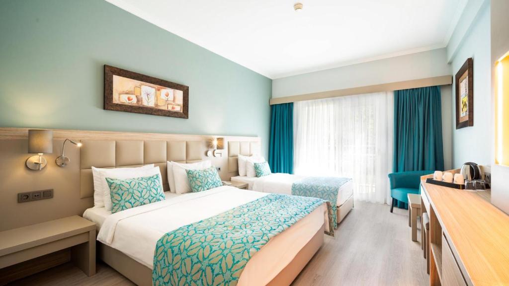 库萨达斯Aqua Fantasy Aquapark Hotel & Spa - Ultra All Inclusive的酒店客房配有两张床和一张书桌