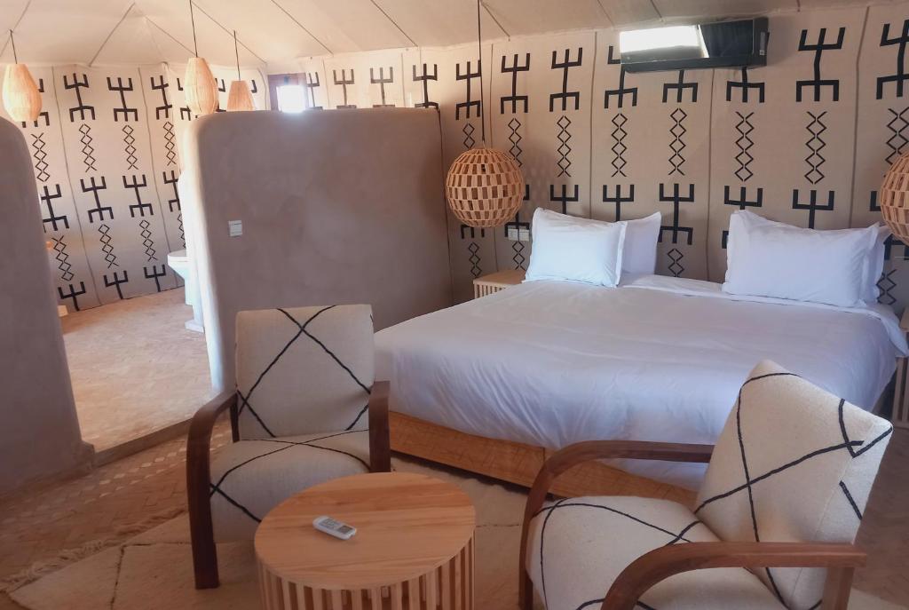 AdrouineNight sky luxury camp的一间卧室,卧室内配有一张床和椅子