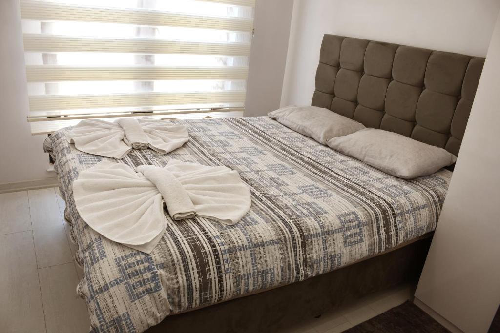 内夫谢希尔Kaya city rezidans的一间卧室,配有一张床,床上有一个弓