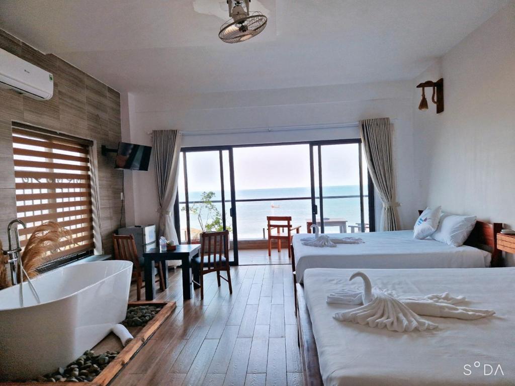 富国Butterfly Rose Beach Resort Phú Quốc Francophone的一间带两张床和浴缸的卧室以及一间浴室