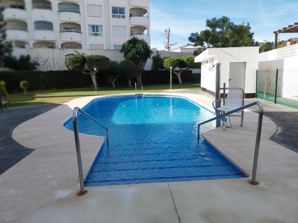 马拉加Chalet en Málaga, Torremolinos, cerca de la playa的大楼前的蓝色海水游泳池