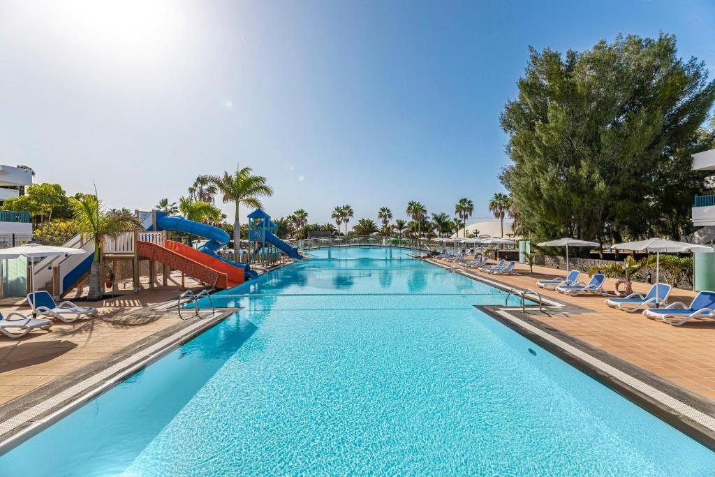 普拉亚布兰卡热带岛屿THB酒店的一个带滑梯和椅子的大型游泳池