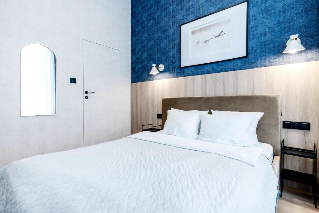 奥尔什丁LIKE LAKES Ukiel Park 39 - Free Parking FV的卧室配有白色大床和蓝色的墙壁