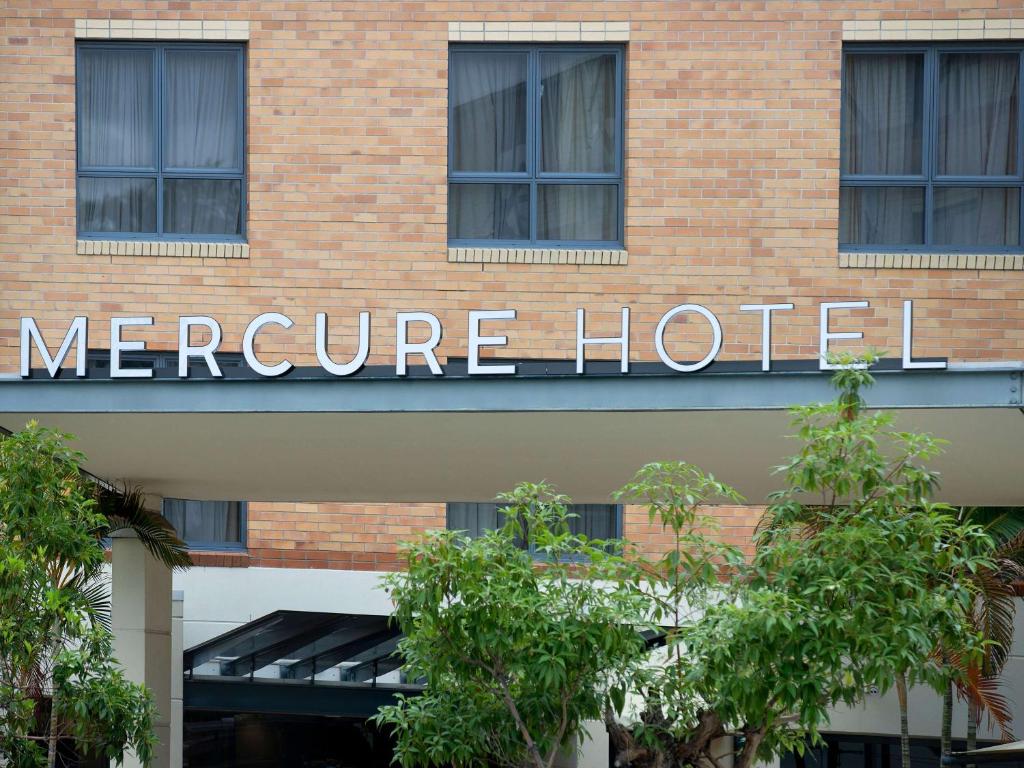 布里斯班Mercure Brisbane Garden City的砖楼一侧的酒店标志