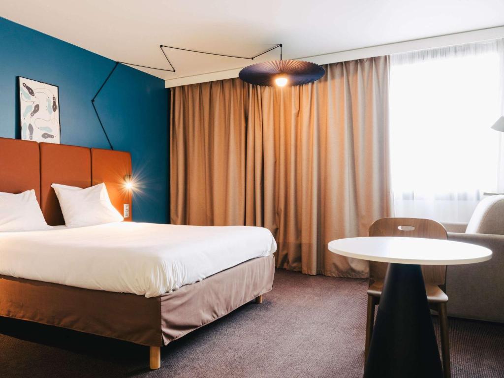 鲁昂坎帕尼尔罗恩梅尔莫兹旅馆的酒店客房配有一张床铺和一张桌子。