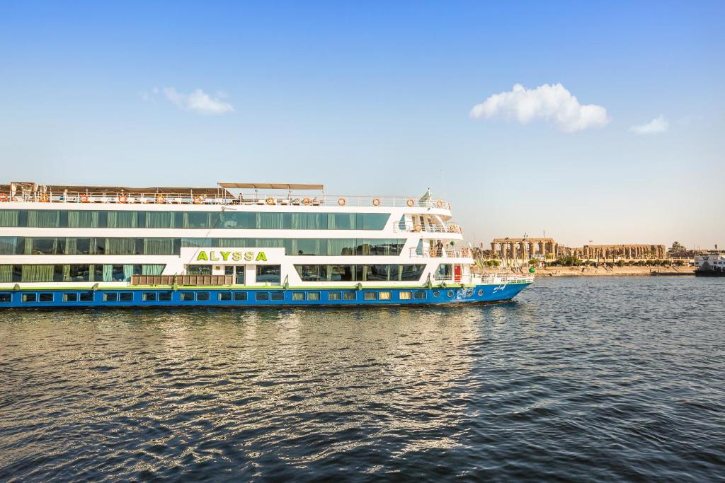 卢克索M/Y ALYSSA - 4 or 7 Nights From Luxor each Monday and 3 or 7 Nights From Aswan each Friday的一艘大游轮在城市附近的水域上