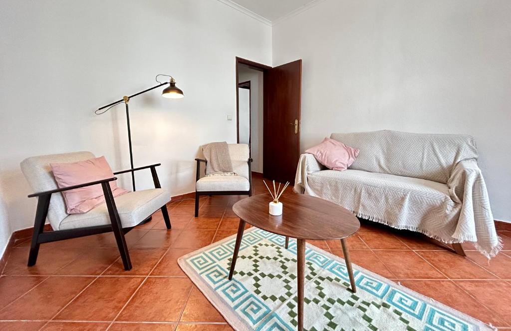FreiriaPortuguese village apartment - Casa Martins No.54的客厅配有两把椅子和一张桌子