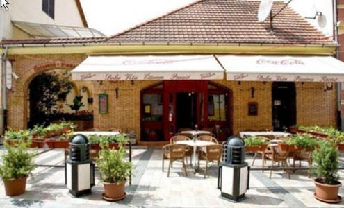 米什科尔茨Dolce Vita Panzió的餐厅设有一座带桌椅的庭院