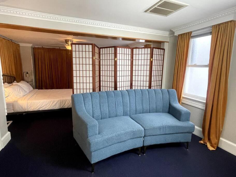 华盛顿Large studio apartment steps from the US Capitol!的客厅配有蓝色的沙发和床。