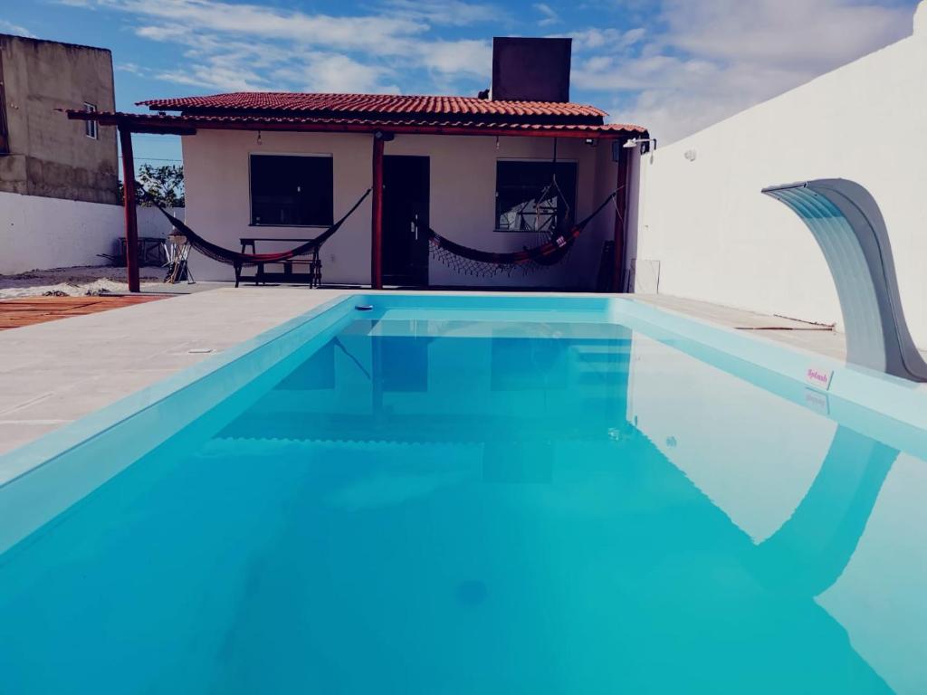 巴拉杜斯科凯鲁斯Casa de Praia Em Aracaju,Se的一座房子前面的蓝色海水游泳池