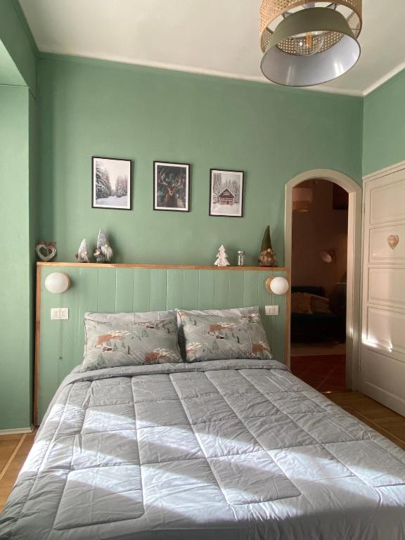 利莫内皮埃蒙特Bilocale a due passi dal centro的一间卧室配有一张带绿色墙壁的床