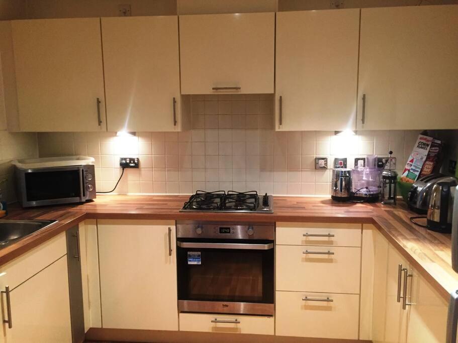 伦敦1 Bedroom Flat near Excel, O2, Canary Wharf - London的厨房配有白色橱柜和炉灶烤箱。