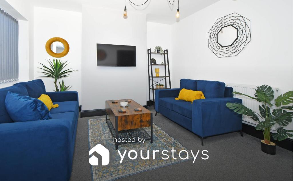 特伦特河畔斯托克Potter's Rest by YourStays的客厅配有2张蓝色的沙发和1张桌子