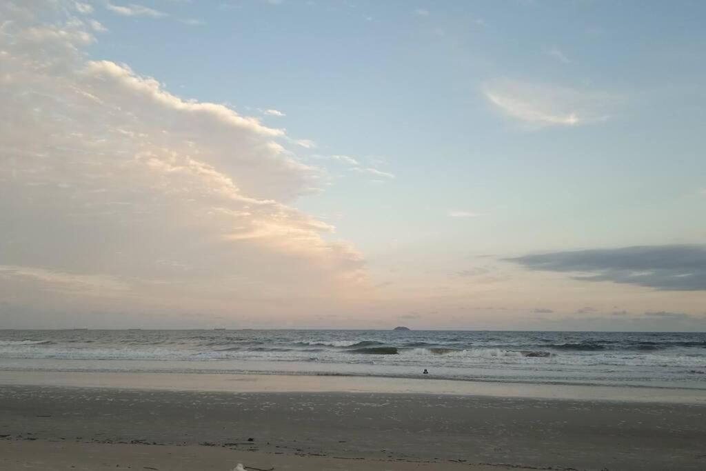巴拉那州蓬塔尔Lindo Apto com vista para o Mar!的一片云天和海洋的海滩