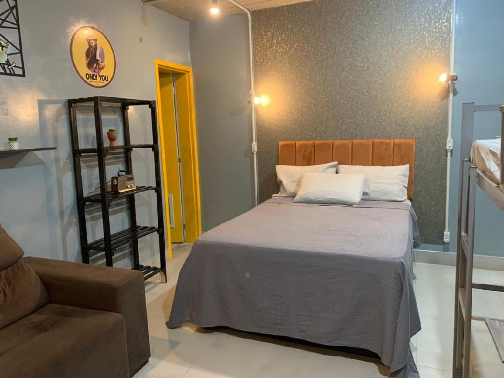 圣保罗Brás, Feirinha da Madrugada, Expo Center Norte, Vaultier的一间卧室配有一张床和一个沙发