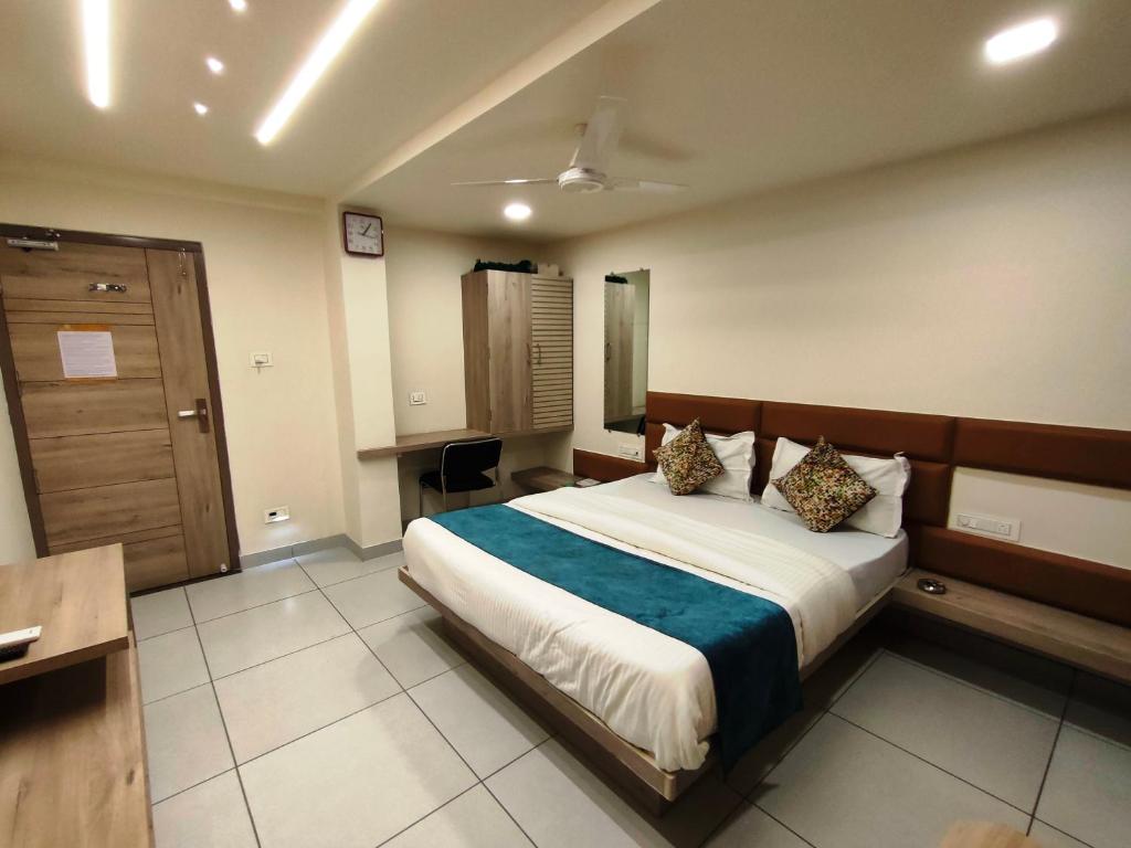 艾哈迈达巴德Hotel Kinara的卧室配有床、书桌和门