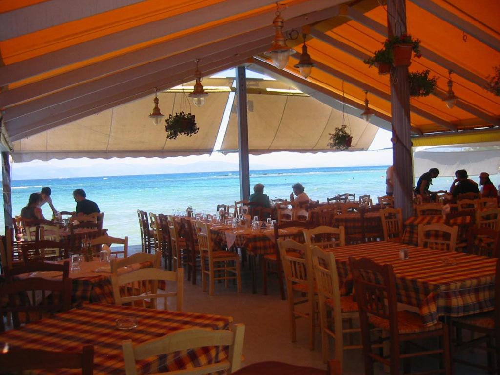 爱琴娜岛Hotel Avra的一间设有桌椅的海洋餐厅