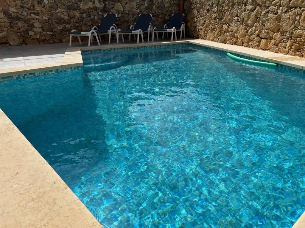休吉让4 Bedroom Holiday Home with Private Pool & Views的一座大型蓝色游泳池,里面配有椅子