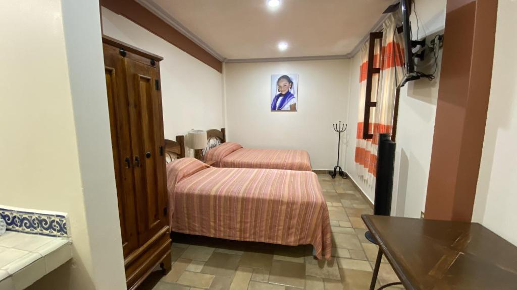 瓦哈卡市Posada Regional的酒店客房设有两张床和一张桌子。