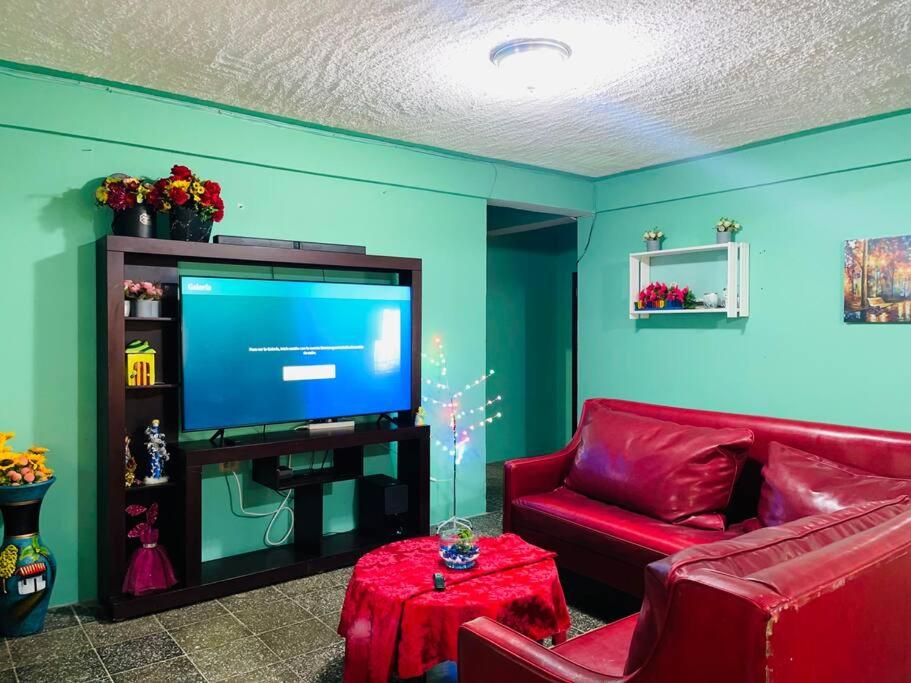 拉塞瓦Agradable casa de 4 habitaciones 2 baños cómodos的客厅配有红色沙发和平面电视