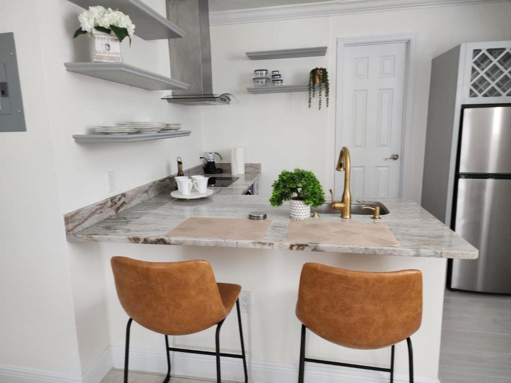 基西米Studio furnished的厨房配有大理石台面和2把椅子
