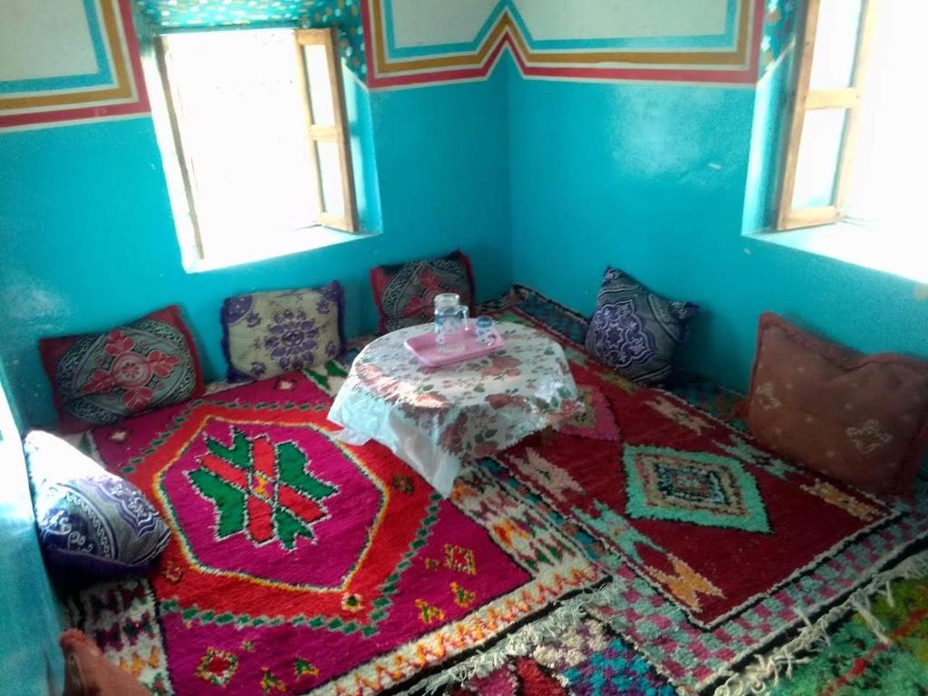 Megdazدارالضيافة git atlas的一间铺有地毯的房间里,配有桌子的房间