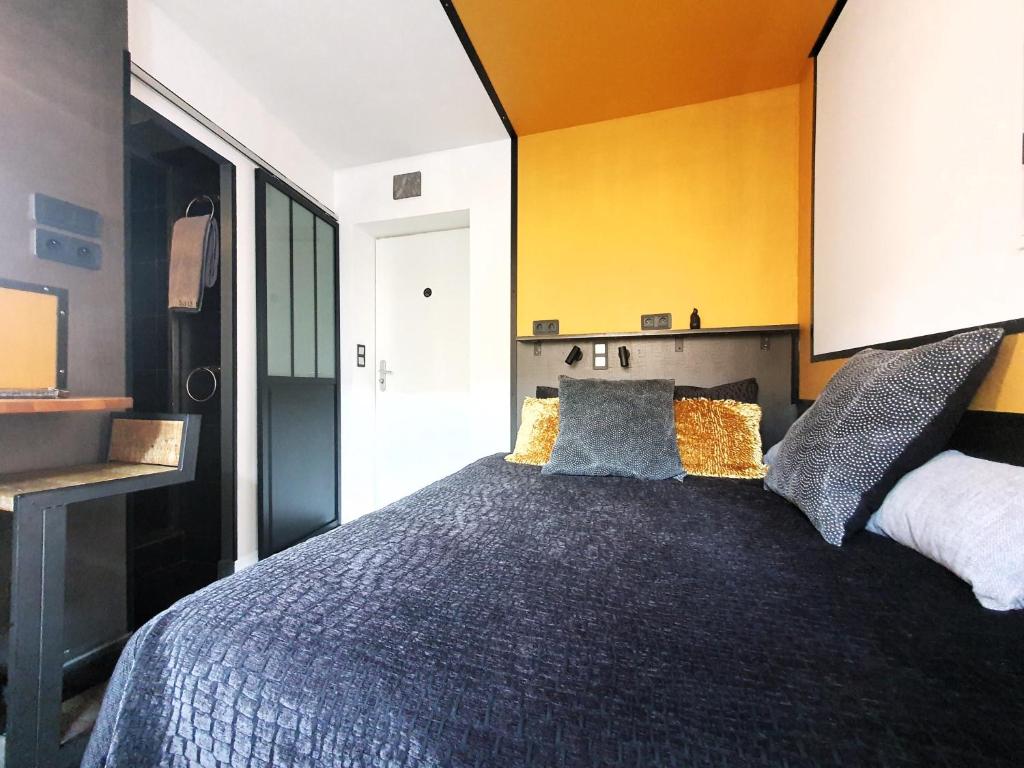 里昂Apartment MiniSteel Loft Brotteaux Part-Dieu的一间卧室设有一张黄色墙壁的大床