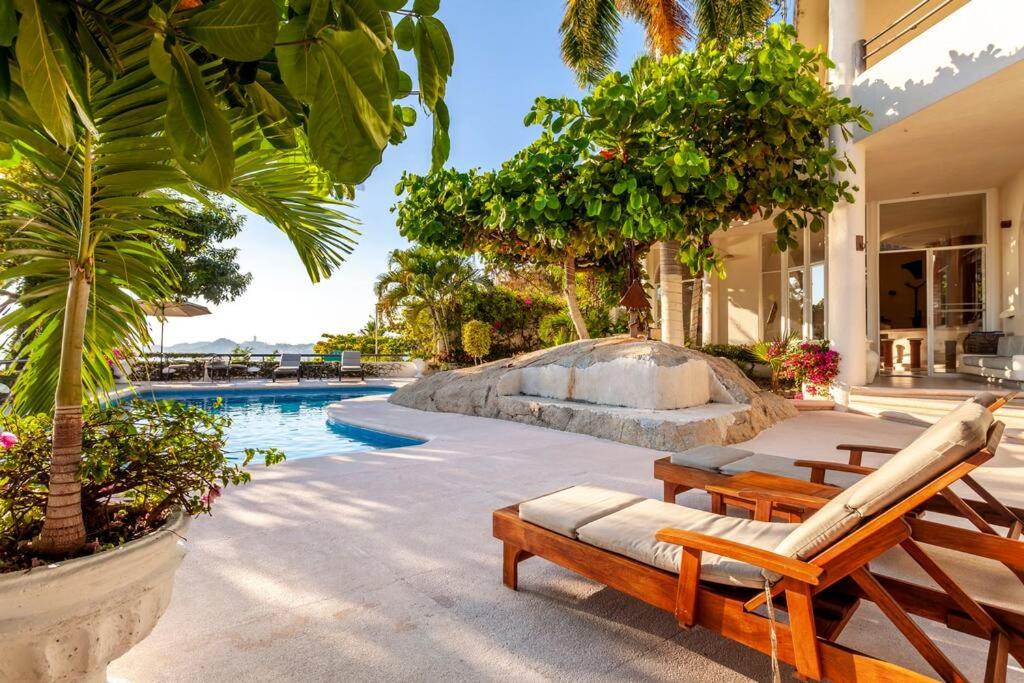 阿卡普尔科Preciosa Villa en Marina Las Brisas的一个带2把躺椅的度假游泳池和一个游泳池