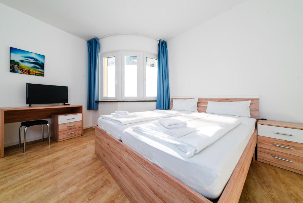 多特蒙德City Rooms Dortmund的一间卧室配有一张大床和电视