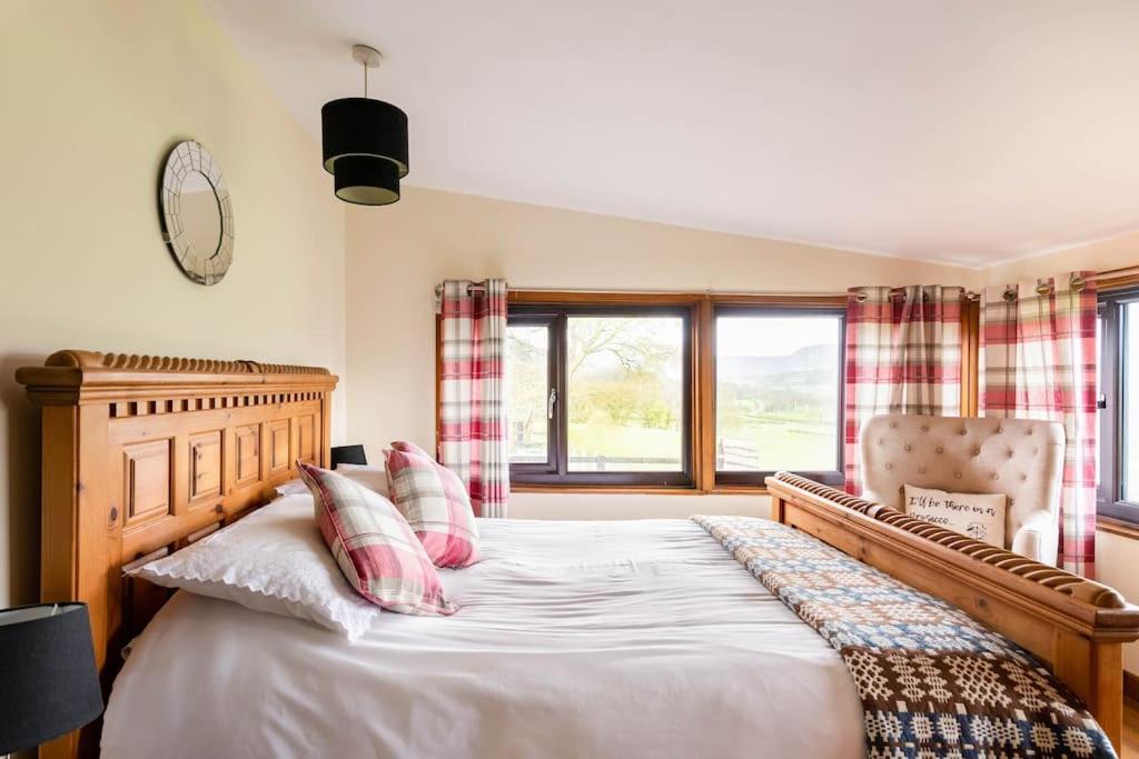 Llanrhaeadr-ym-MochnantThe Retreat的一间卧室配有一张床、一把椅子和窗户。