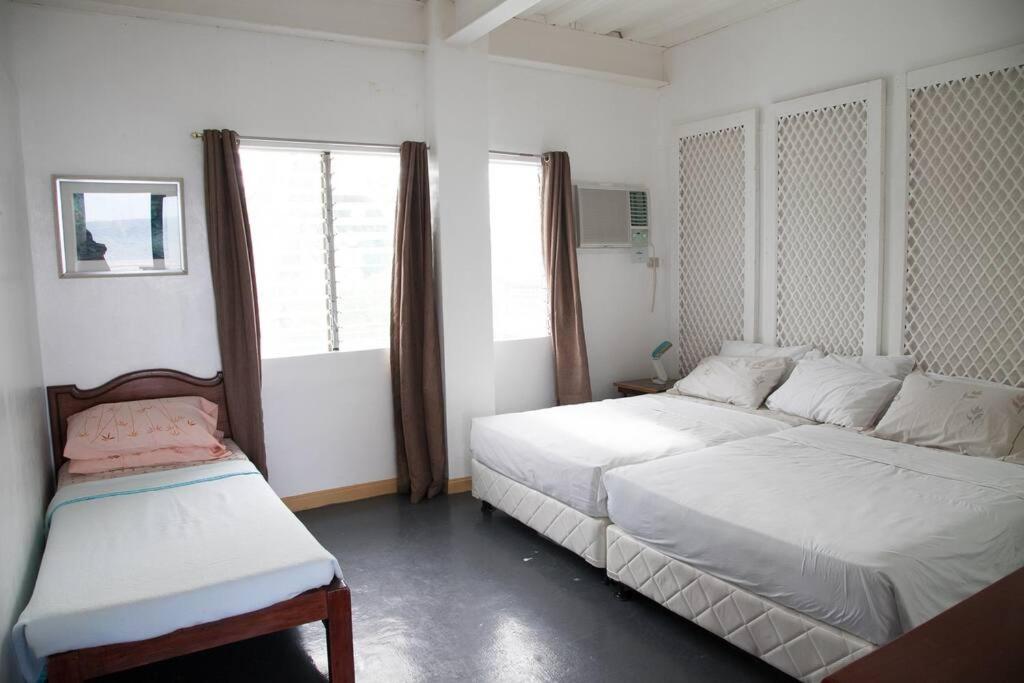 BuenavistaVilla Elena Guimaras的一间白色卧室,配有两张床和窗户