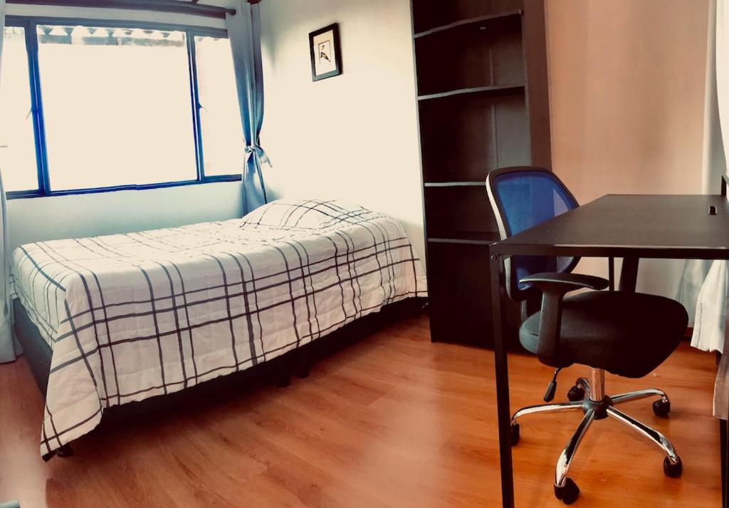 马尼萨莱斯Alojamiento Cuarto Espiral的一间小卧室,配有一张床、一张桌子和一把椅子