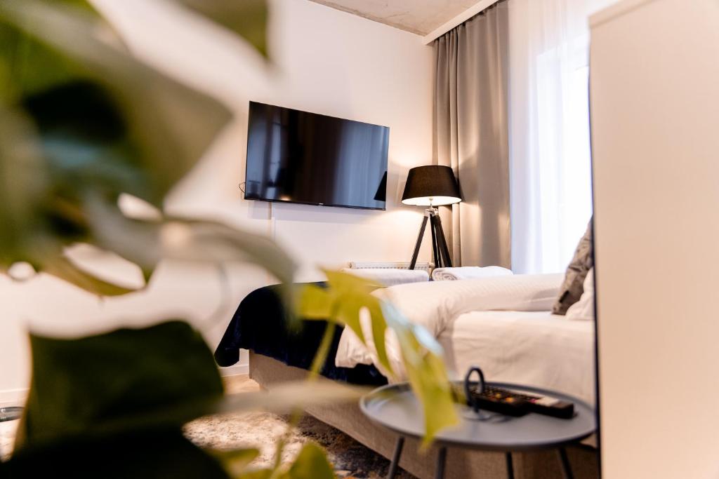 戈莱纽夫Hop & Lulu Delux Apartments的客厅配有沙发和墙上的电视