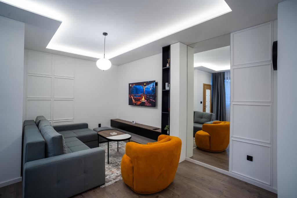 帕莱Apartman G1的带沙发和橙色椅子的客厅