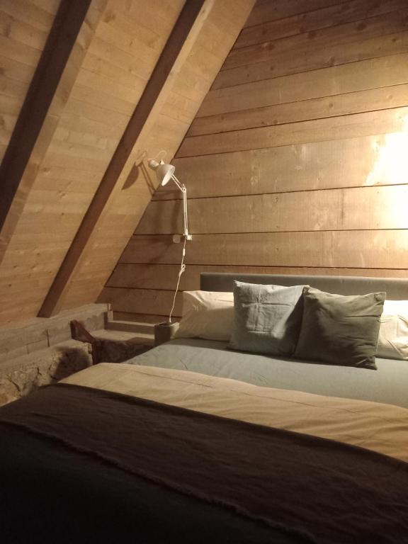 新瓦罗什ZlatAir Twins的一间卧室配有一张木墙床