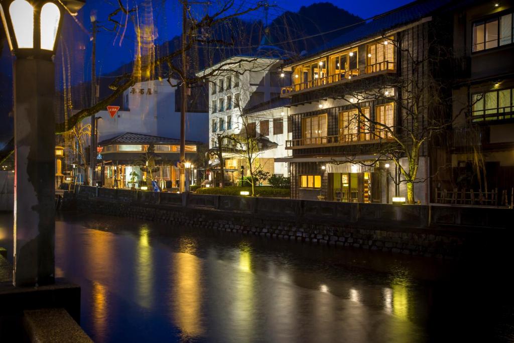 KinosakiKinosaki onsen Tokitotoki的一座有建筑的城市,晚上有河流